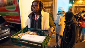 Badalona, 24/12/2025. Sociedad. Voluntarios de distintas entidades privadas reparten comida para la cena de Nochebuena bajo la autopista C-31, donde aún duermen decenas de personas desalojadas del antiguo instituto B9. Foto: Zowy Voeten / El Periódico