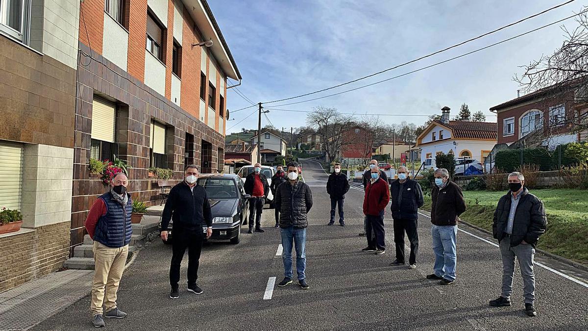 Por la izquierda, los concejales Eduardo Llosa, Alejandro Villa y Javier Rodríguez, ayer, rodeados de vecinos de la parroquia de Santiago Arenas, a la que afecta la actuación. | R. A. I.