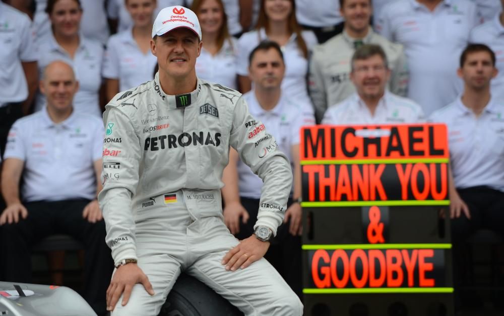 El piloto alemán de Fórmula Uno Michael Schumacher posa con el equipo de Mercedes en los boxes
