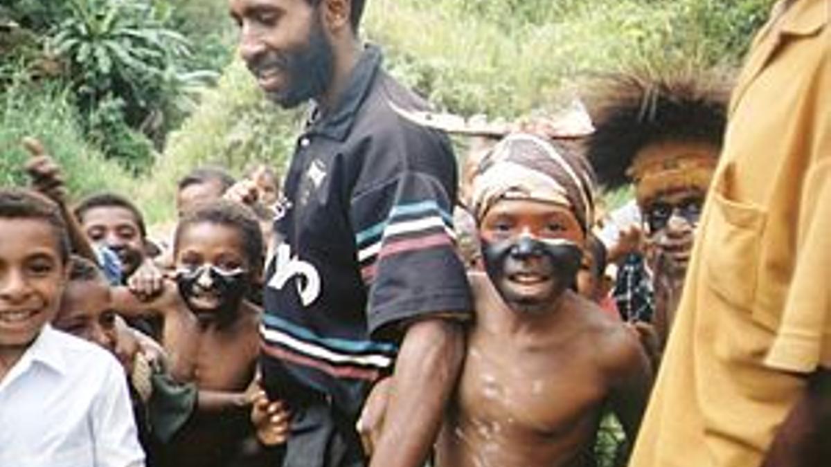 Hombre junto a niños vestidos de forma tradicional en Papúa Nueva Guinea.