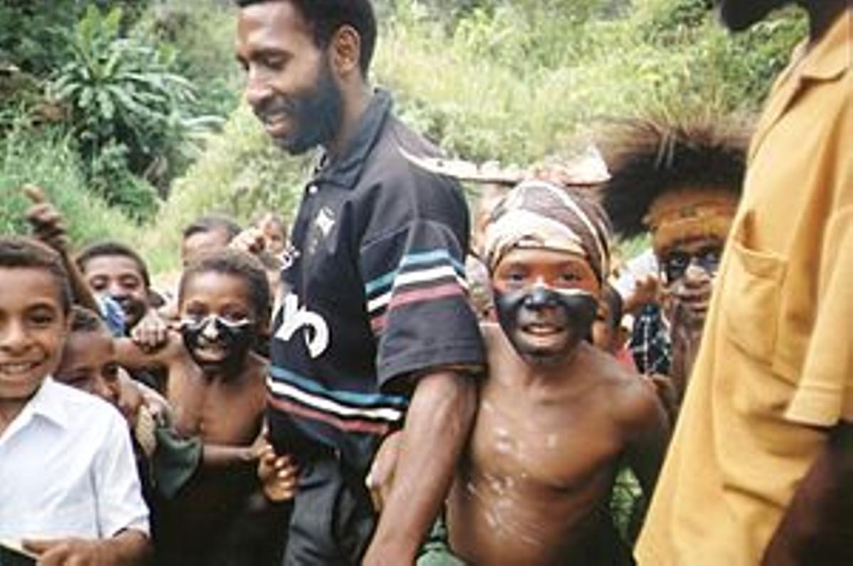 Hombre junto a niños vestidos de forma tradicional en Papúa Nueva Guinea.