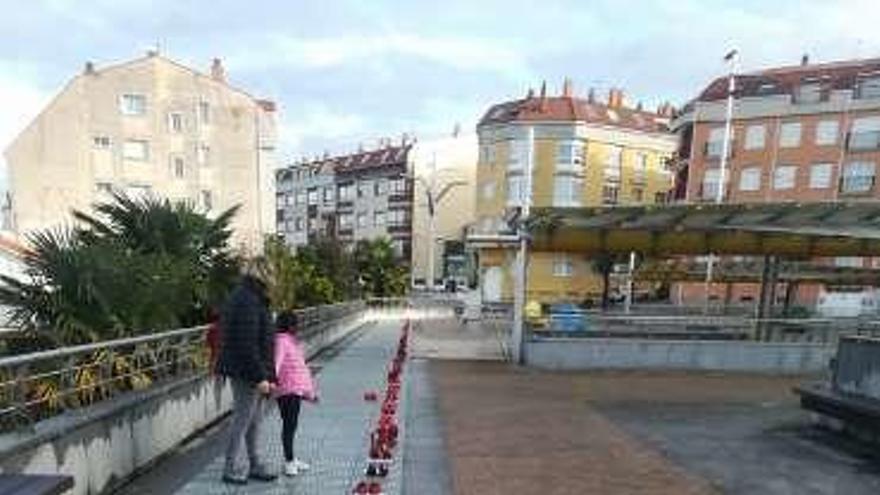 Participantes en el acto celebrado ayer en Miño contra la violencia de género y, a la derecha, el camino de zapatos rojos en recuerdo a las víctimas.