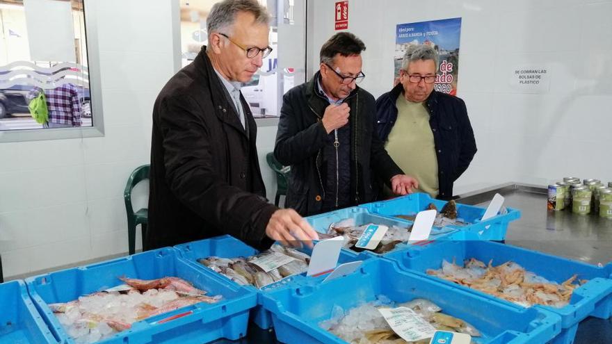 El presidente de la federación de pescadores, primero por la derecha, junto a autoridades autonómicas en la lonja de Cullera.