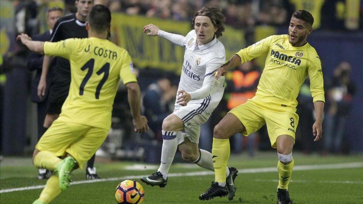 Modric intenta avanzar entre Dos Santos y Jaume Costa