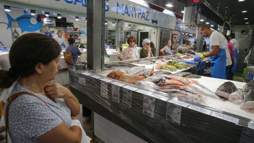 Una mujer compra en un mercado de Galicia.