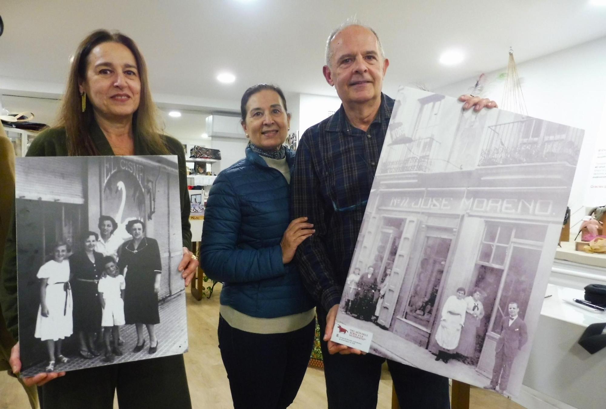 Damián y su prima Gemma sostienen fotos antiguas del comercio junto a la mujer de este, Ángeles.