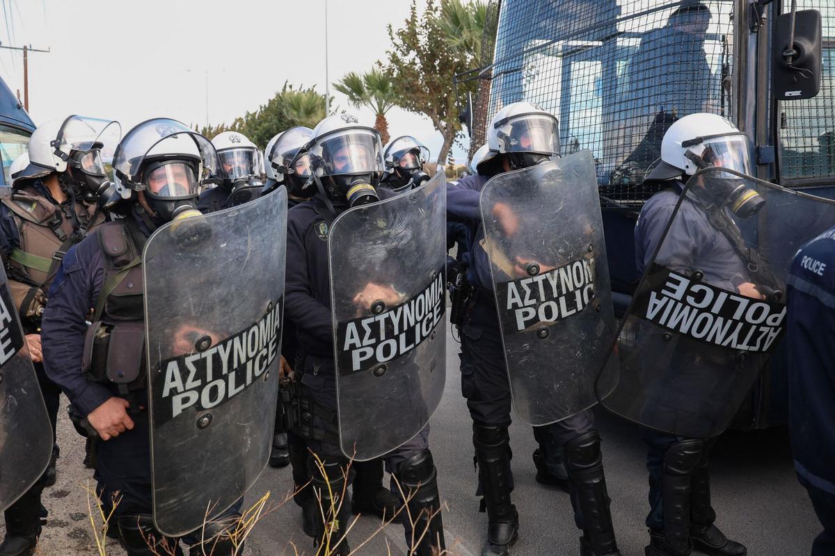 Riot police block the main access road to the airport during a farmers protest in Heraklion, on the island of Crete, on December 8, 2025. Farmers on Crete on Monday clashed with riot police near the Greek islands international airports in a burgeoning protest wave related to an EU subsidy probe. (Photo by Costas METAXAKIS / AFP)