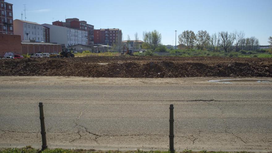 Una excavadora y un tractor trabajan en la explanación del terreno.