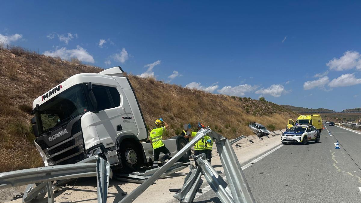 Un camión y un coche, visiblemente dañados, fuera de la carretera tras una colisión.