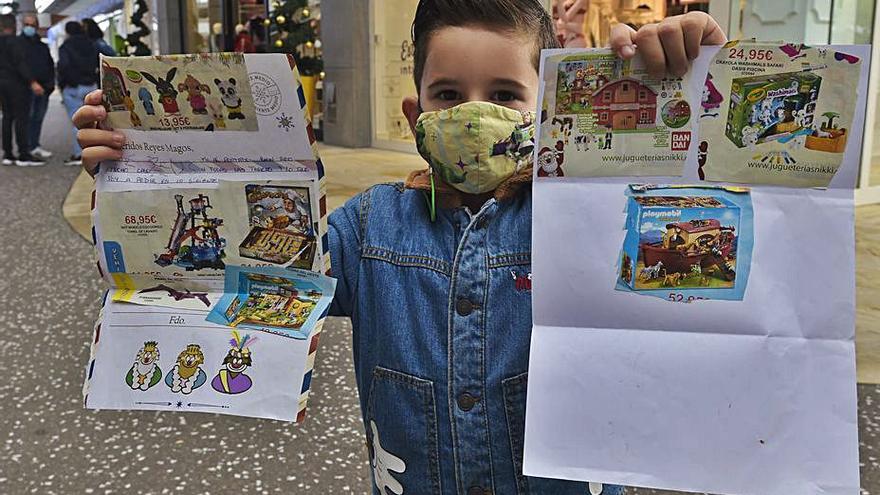 El pequeño Zeus sostiene la carta a los Reyes Magos y a Papá Noel que ha confeccionado recortando catálogos de juguetes