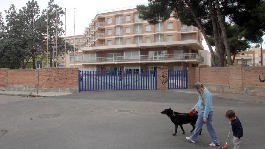 Una mujer paseando a un perro y, a su lado, un niño arrastrando un coche de juguete, ayer junto a la residencia de Fuente Cubas.