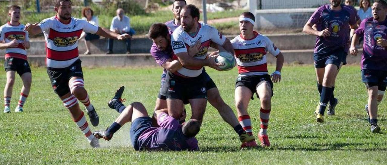 Un jugador del Gijón trata de zafarse de dos contrarios.