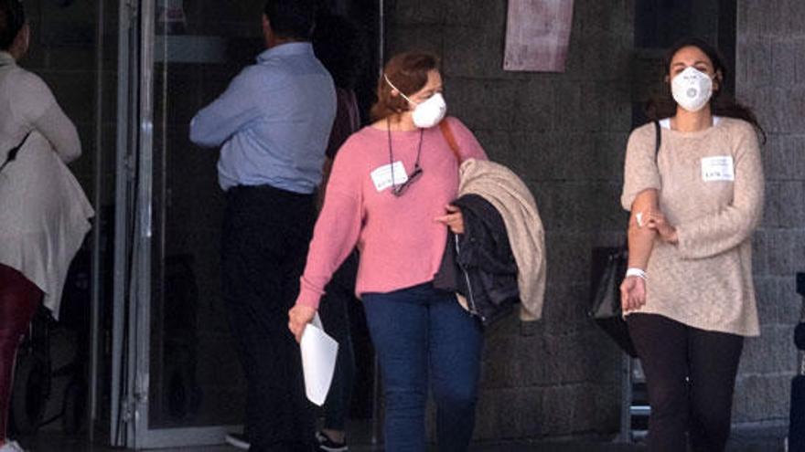 Dos mujeres salen de un hospital con mascarillas en Huelva.