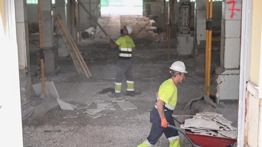 El interior del Mercado Central, donde ya se pueden ver los restos que aparecieron en la primera planta tapados, con dos operarios trabajando este martes. / Áxel Álvarez