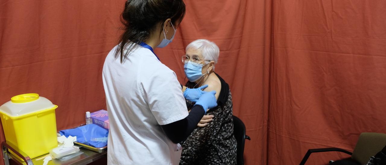 Una sanitària administra una dosi d&#039;una vacuna contra la covid al Palau Firal de Manresa