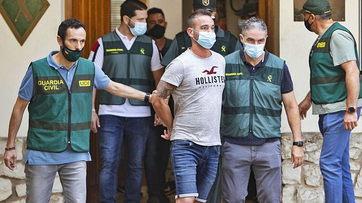 El presunto asesino, rodeado de los investigadores, de camino al registro de su casa.