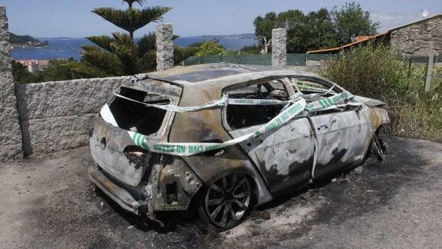El segundo coche incendiado, ayer a mediodía, con el precinto de la Guardia Civil. // Santos Álvarez