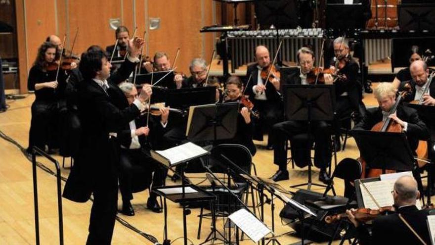 Óliver Díaz dirige a la OSPA durante el concierto en el Auditorio.