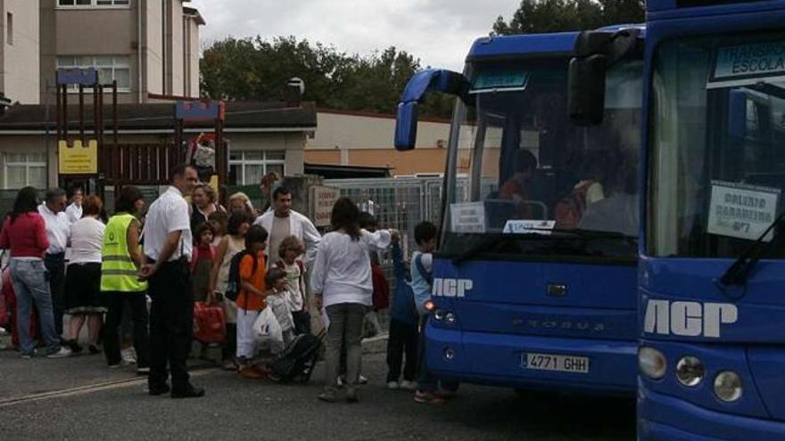 Alumnos de un colegio de Razo suben al autobús escolar tras concluir las clases. / m. carmen suárez
