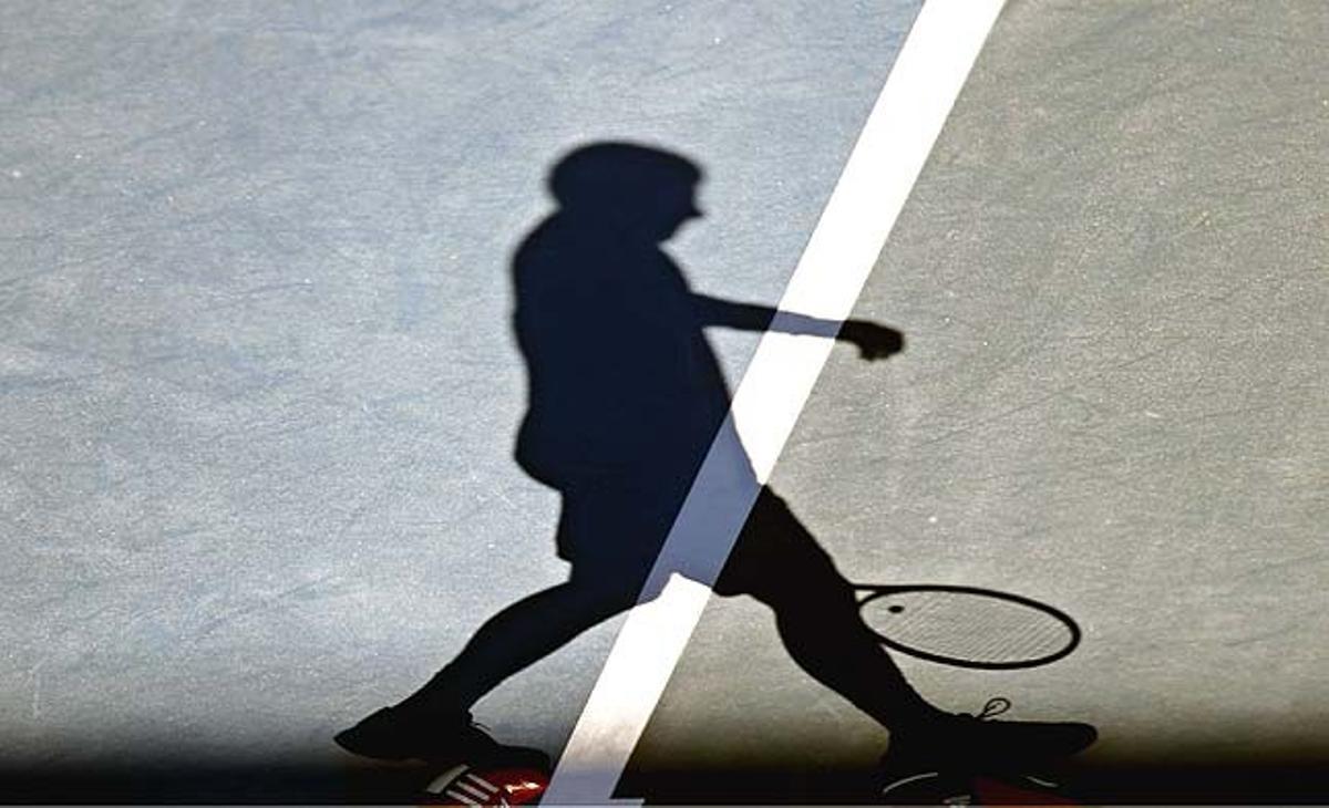 El serbi Novak Djokovic projecta la seva ombra sobre la pista durant un entrenament al Melbourne Park (Austràlia) a l’espera del primer Grand Slam de l’any.