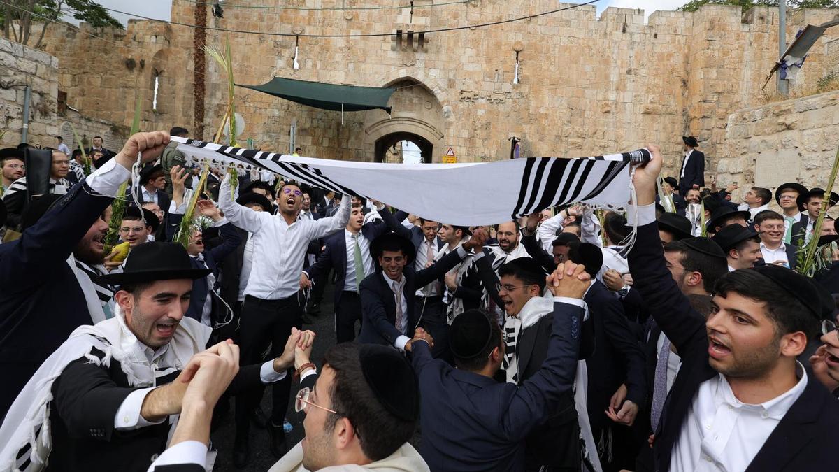 Judíos ortodoxos bailan y rezan durante la festividad del Sucot cerca de la Puerta de los Leones, uno de los principales accesos a la ciudad vieja de Jerusalén y cercana a la mezquita de Al Aqsa, este martes.