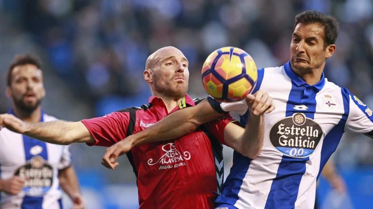 El delantero del Alavés Toquero pelea un balon con el centrocampista costarricense del Deportivo Celso Borges.