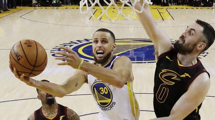 Stephen Curry trata anotar ante varios jugadores de los Cavs.