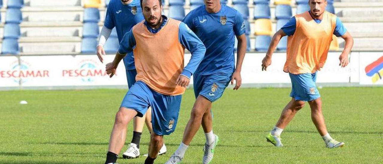 Jacobo conduce un balón durante un entrenamiento seguido de Loureiro y Álex Fernández. // Rafa Vázquez