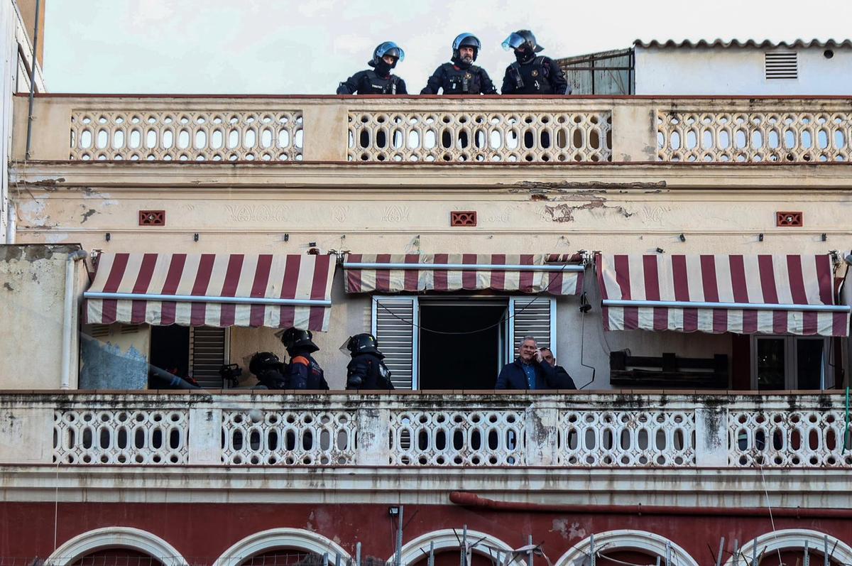 Agentes de los Mossos d'Esquadra en la terraza de la finca okupada