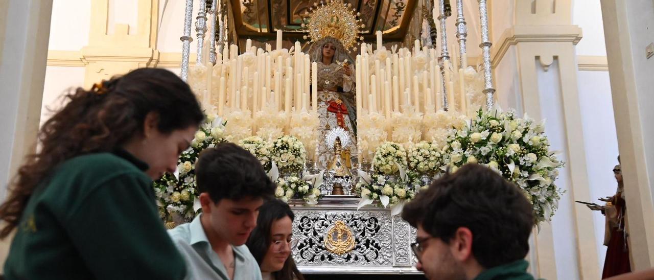 Un grupo de jóvenes ultima los detalles de un paso de palio de la Semana Santa cordobesa.