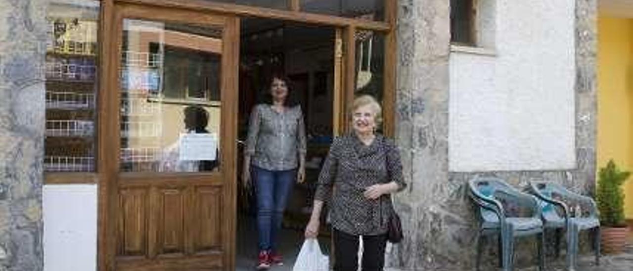 Corina Porojnicu atiende a Alberto Augusto en la farmacia de El Campu.