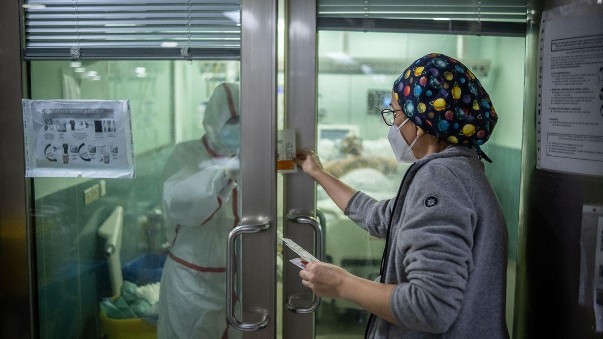 Dos sanitarios atienden a una persona ingresada en la UCI.