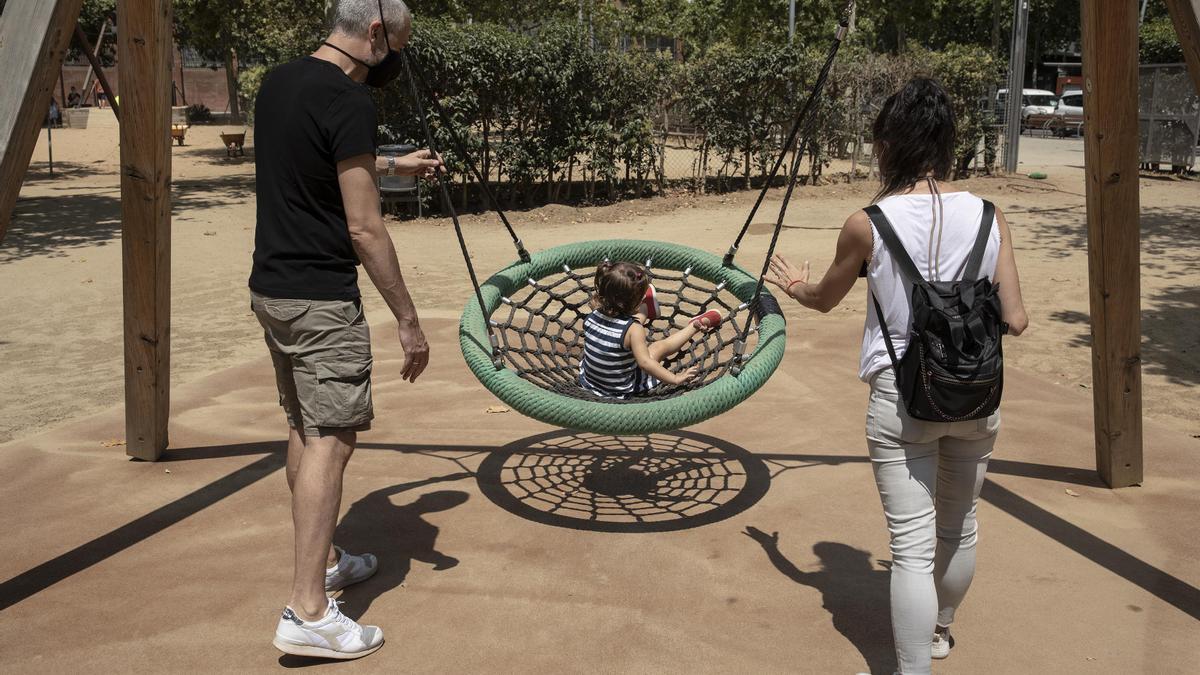 Dos padres con su hija en un parque.