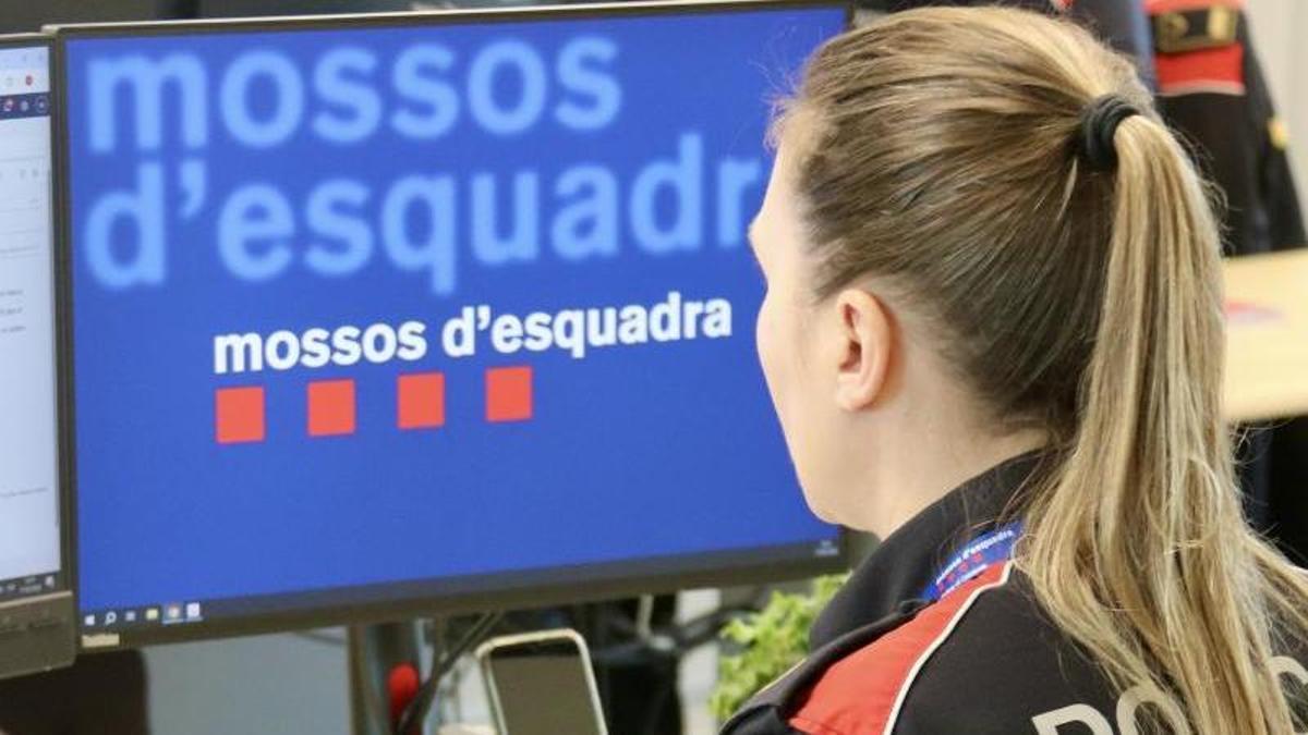 Una agente de los Mossos d'Esquadra, en su puesto de trabajo en una comisaría.