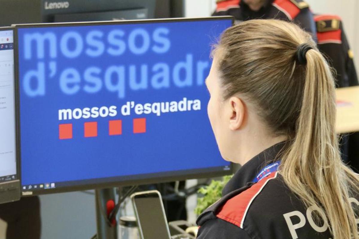Una agente de los Mossos d'Esquadra, en su puesto de trabajo en una comisaría.