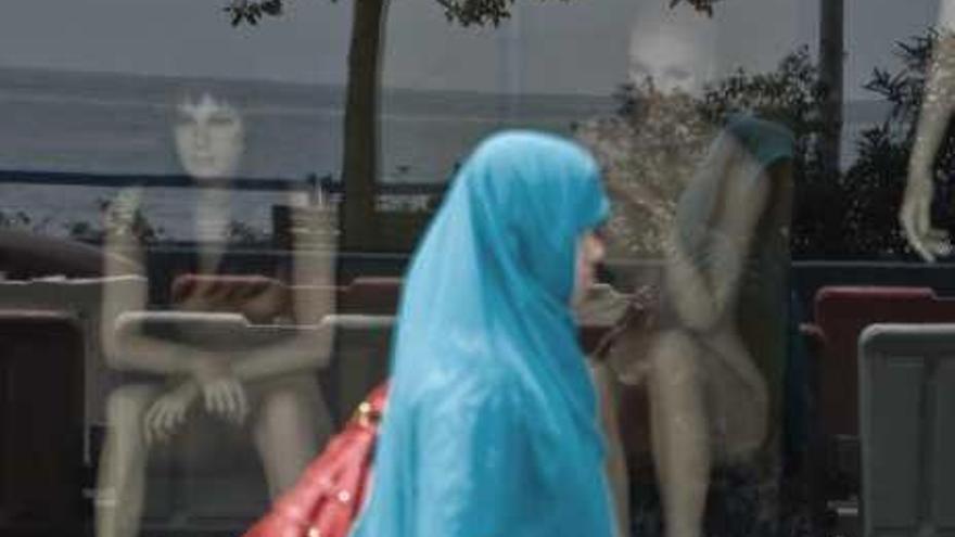 Una mujer musulmana pasa frente a una tienda en Alicante.