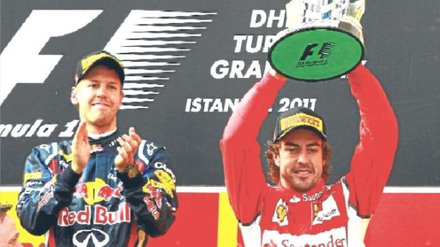 Sebastian Vettel aplaude mientras Fernando Alonso levanta la copa del tercer clasificado del GP de Turquía.