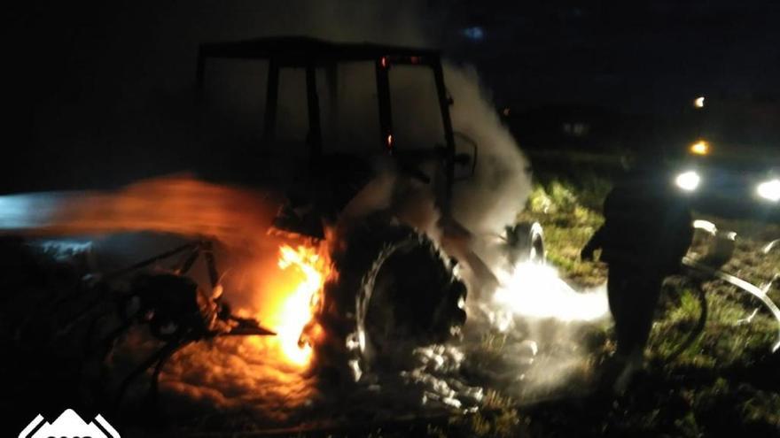 Un bombero junto al tractor en llamas de Serantes.