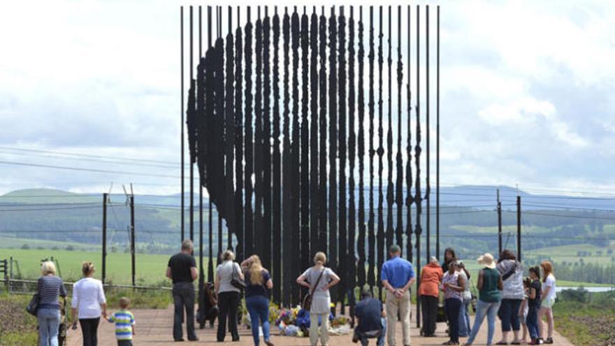 Un grupo de personas reunidas ante un monumento a Mandela