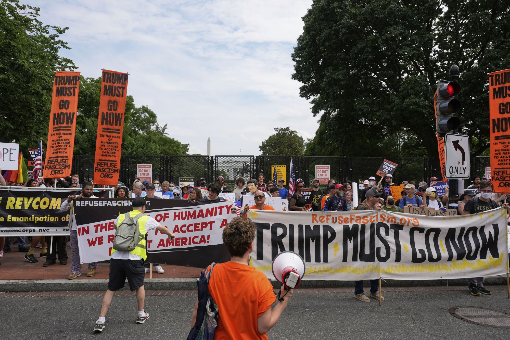 Demonstrators stand near the White House during a protest taking place on the day of a military parade commemorating the Army's 250th anniversary, coinciding with President Donald Trump's 79th birthday, Saturday, June 14, 2025, in Washington. (AP Photo/Alex Brandon)