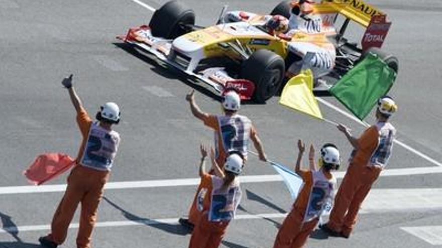 El piloto de Renault, Fernando Alonso, a su paso ante los comisarios de pista, al finalizar el Gran Premio de Europa de Fórmula Uno que se ha disputado en el Circuito Urbano de Valencia.