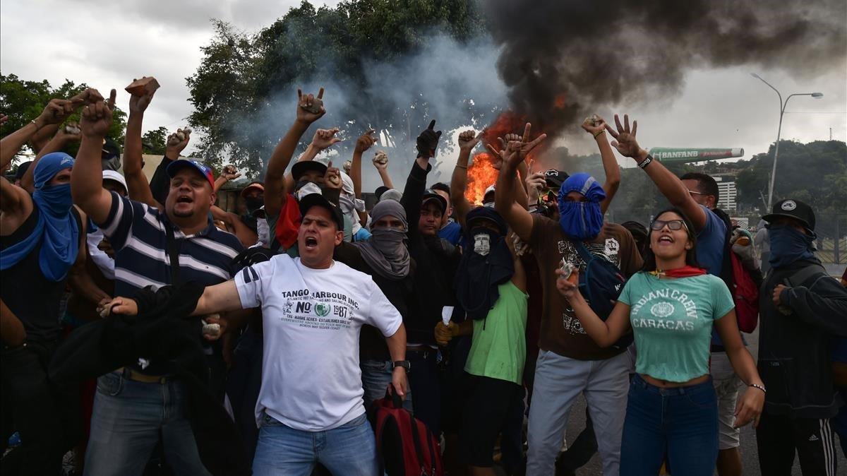 Manifestantes contra el gobierno de Nicolás Maduro cantan eslogans de protesta en Venezuela