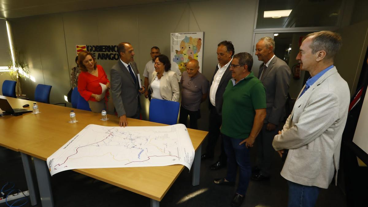 El consejero de Sanidad, José Luis Bancalero, señala el mapa de la zona afectada por la contaminación ante la mirada de los alcaldes afectados y otros representantes institucionales.