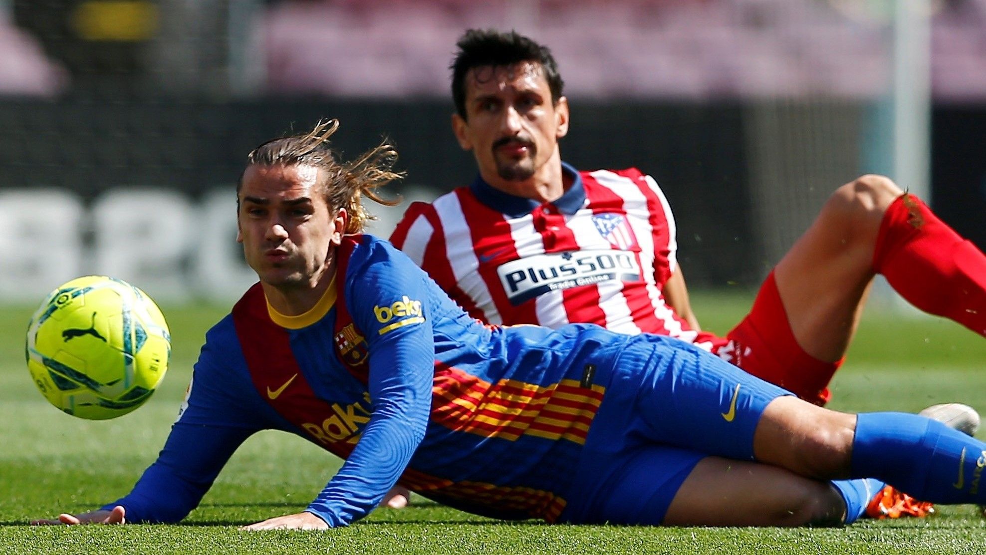 Antoine Griezmann, jugador del FC Barcelona, pugna por el balón contra el defensa del Atlético de Madrid Stefan Savic en un partido de Liga en el Camp Nou de Barcelona.