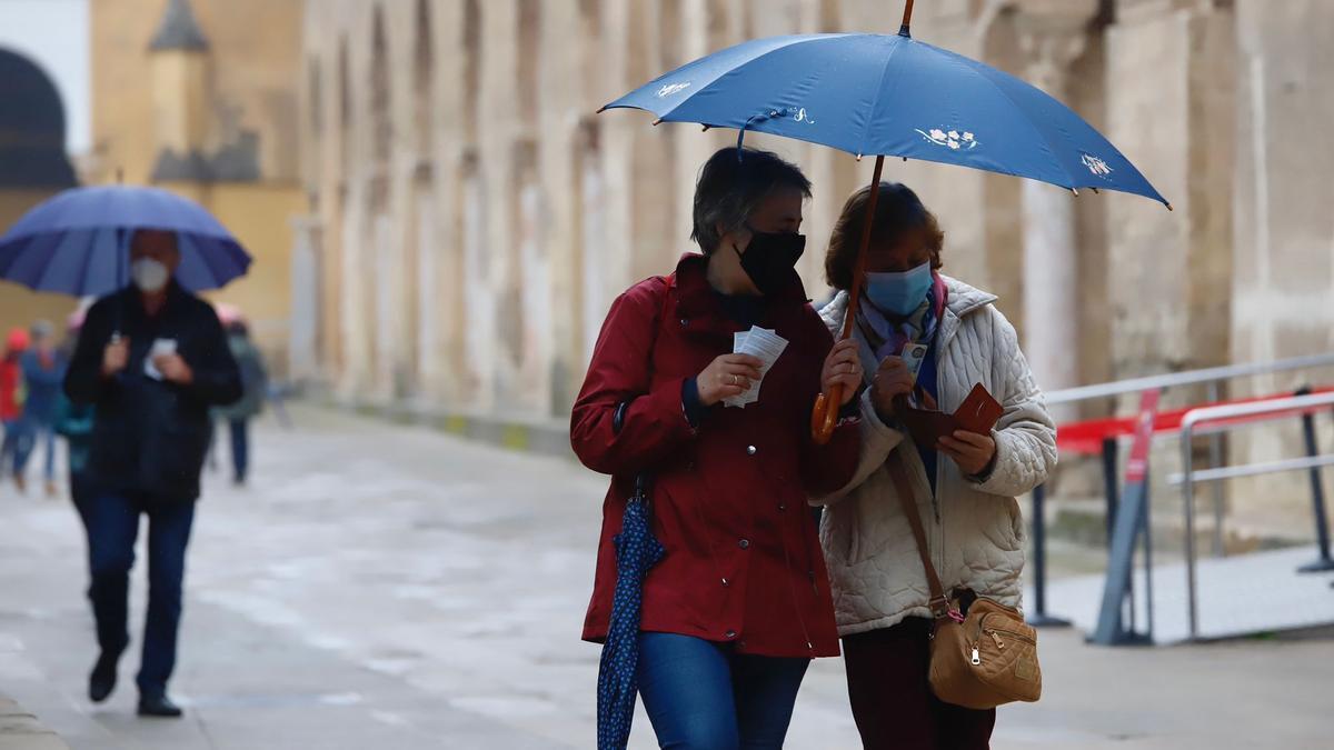 Turistas en Córdoba con paraguas.