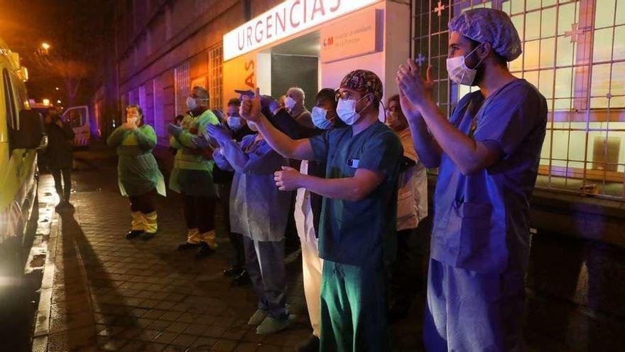 Sanitarios del Hospital Universitario La Princesa de Madrid responden a los aplausos de los vecinos por su labor. // Efe