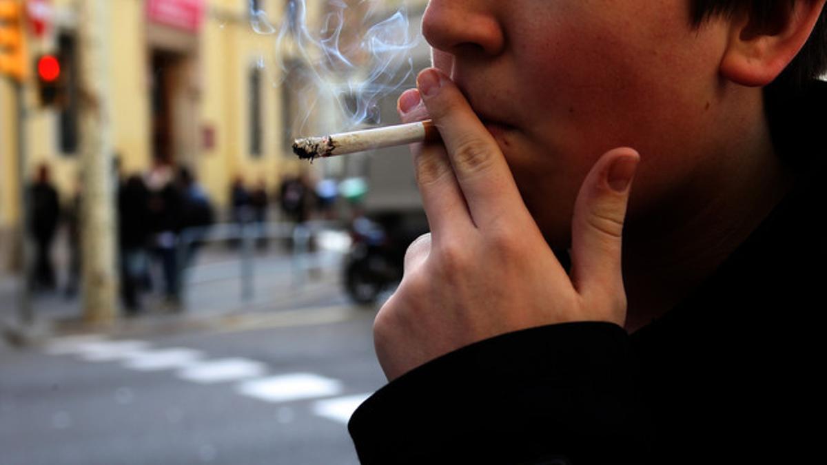 Un joven fumando un cigarro.