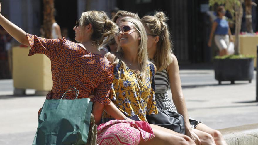 Turistas extranjeros se refrescan y hacen fotos en València.  eduardo ripoll