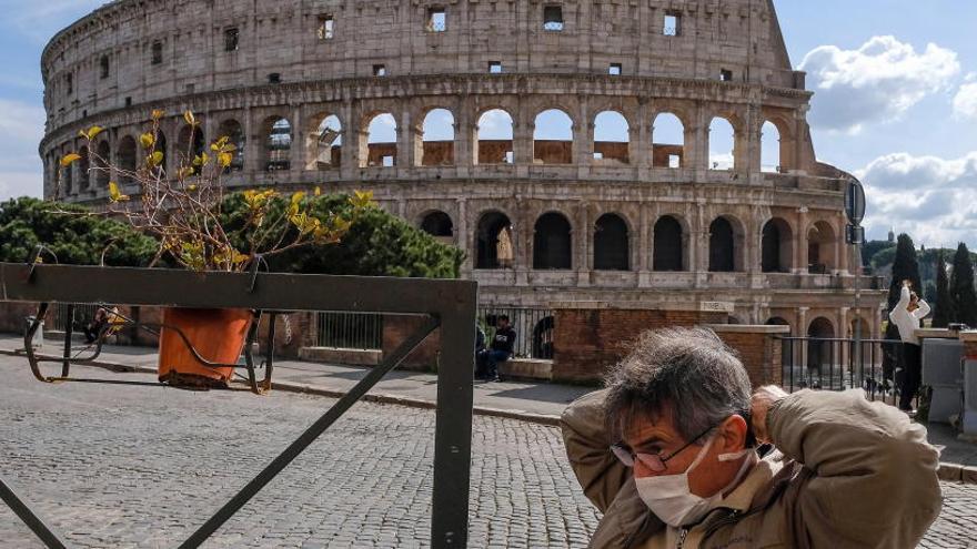 Una mujer con mascarilla junto al Coliseo de Roma.