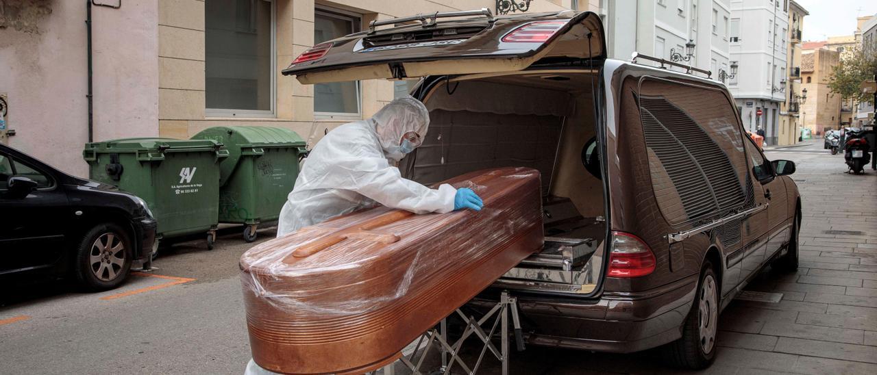 Trabajador de una funeraria sacando el cuerpo de un fallecido por covid de una residencia de València en 2020.